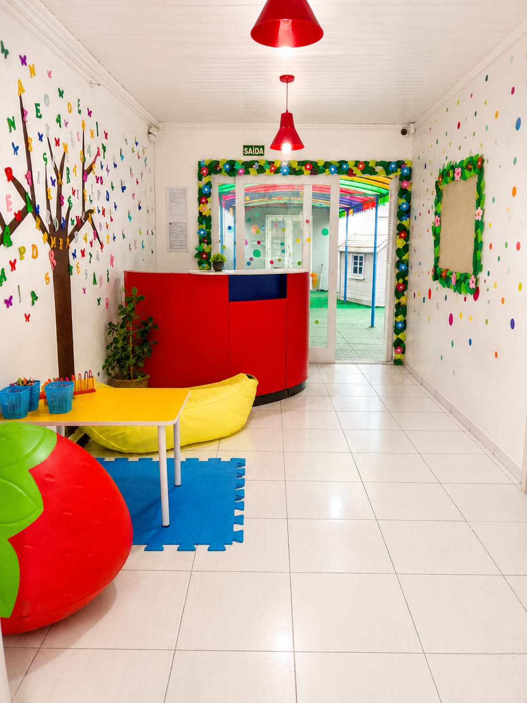 Recepção da escola com decoração colorida e árvore de letras